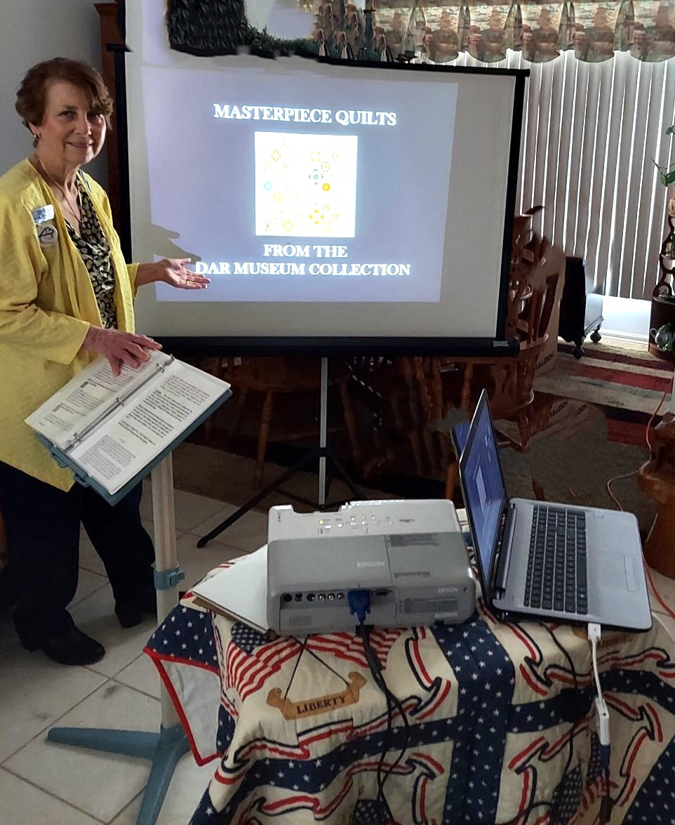 Woman doing a presentation on quilts