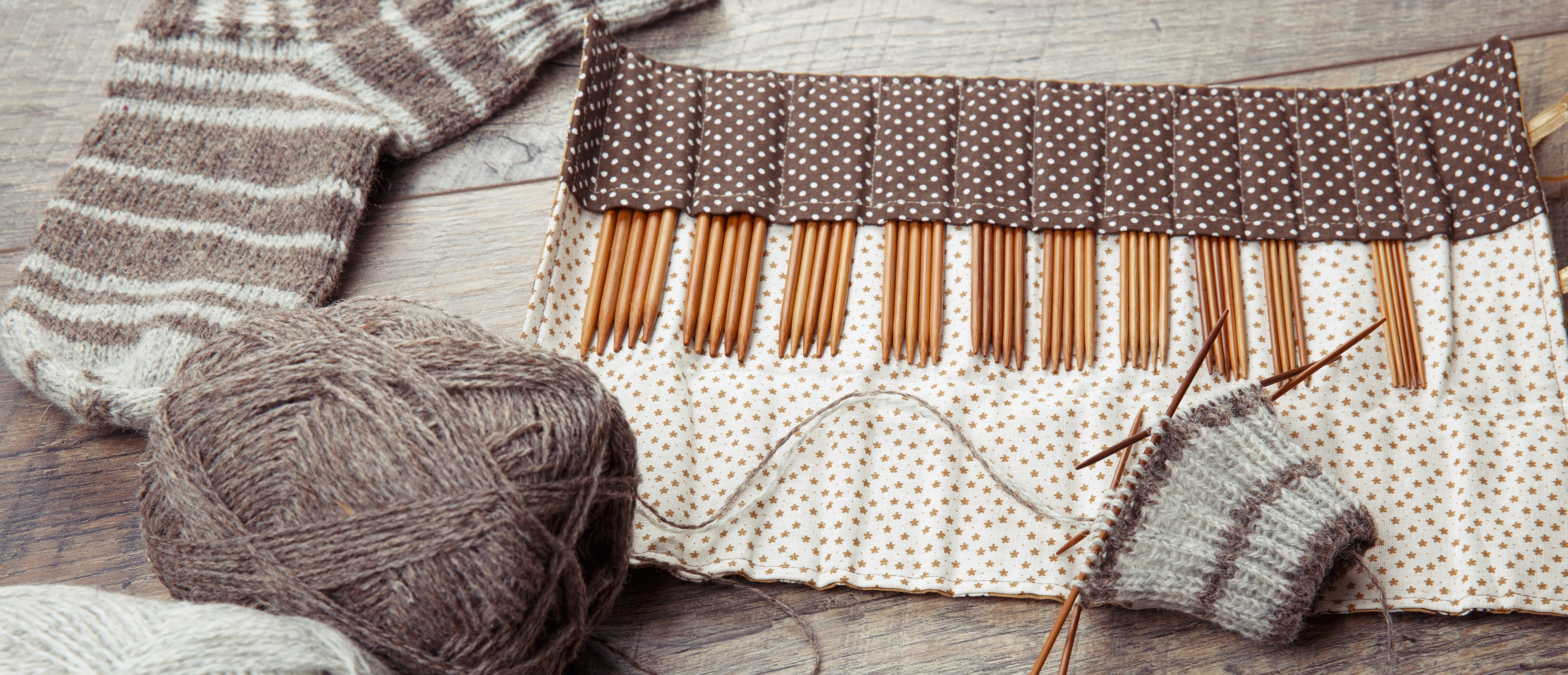 Brown yarn and knitting needles knit a sock