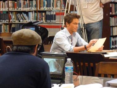 Rob Lowe examining one of the documents containing information about his ancestor.